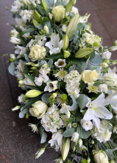 Luxury White Casket Spray - A stunning white and green design including lilies, roses, hydrangea and lisianthus creating a lavish tribute with a classic design.  Available in Standard 4ft, medium 5ft, large 6ft. Delivered by your local florist Susettes flowers.