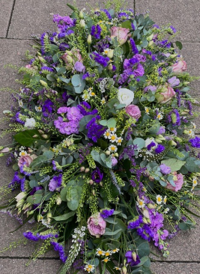 Purple and Lilac Casket Spray - A country style tribute of deep purple and cool lilac tones creating a beautifully stylish floral design, available in sizes standard 3ft, medium 4ft, large 5ft. Hand delivered by your local florist at Susettes flowers.